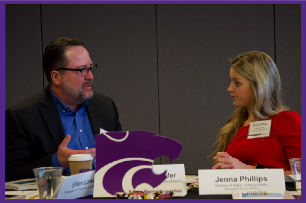 Two people seated at a table having a serious discussion.